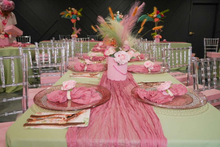 Elegant pink-themed table setting with floral centerpiece and delicate decorations.