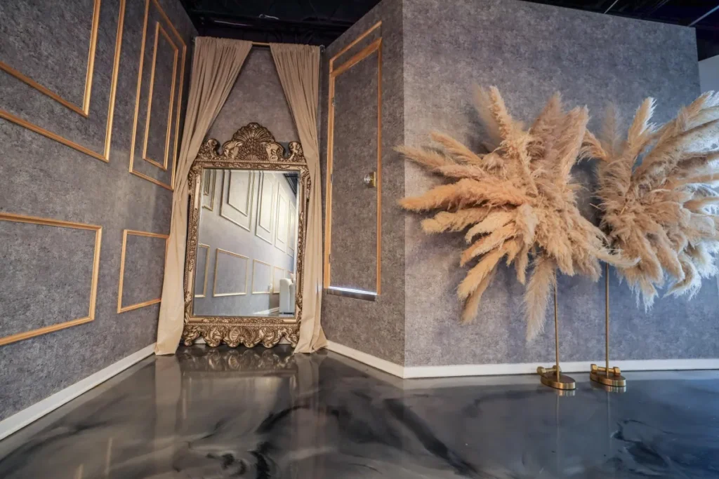 Elegant room with ornate mirror and pampas grass wall decor.